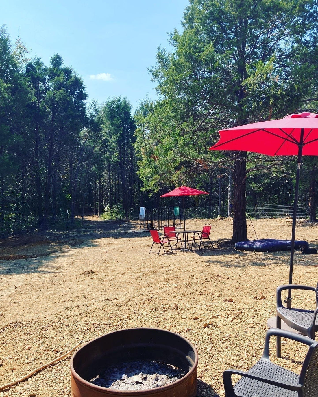 The WestLand Farm land in early fall with red umbrellas and fire pit