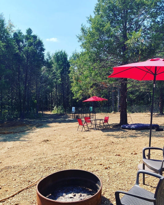 The WestLand Farm land in early fall with red umbrellas and fire pit