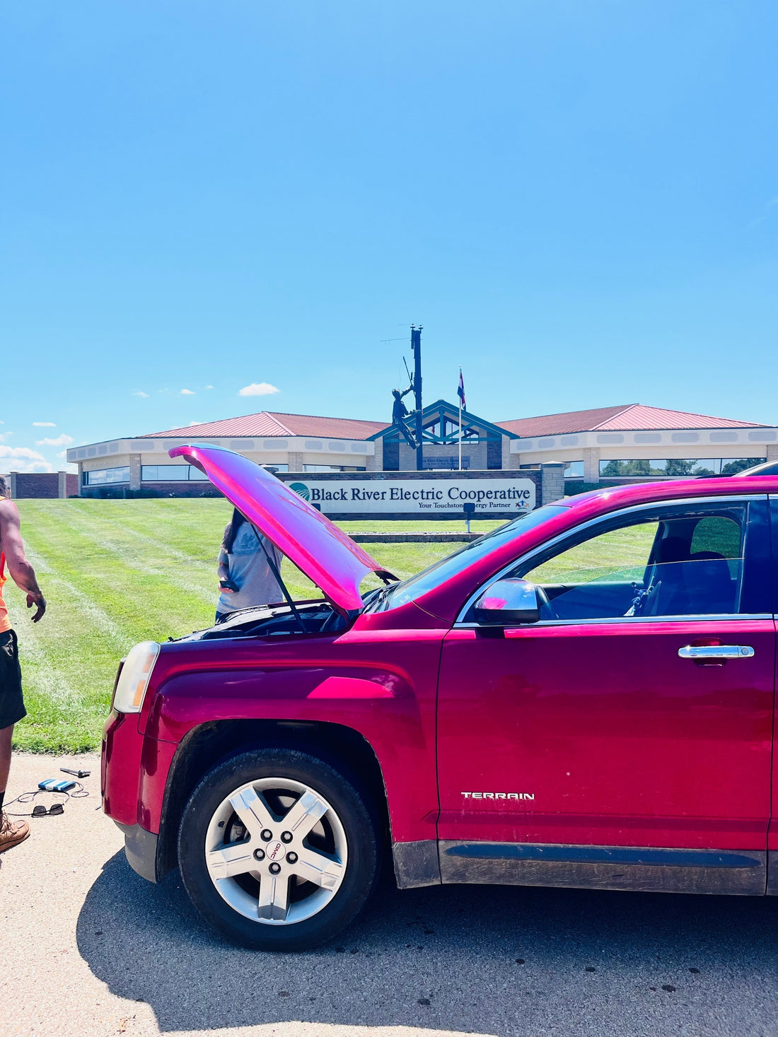 Hood up on our GMC Terrain in the Black River Electric Cooperative parking lot during a summer heatwave breakdown